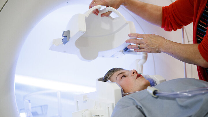A boy gets placed in an MRI machine.